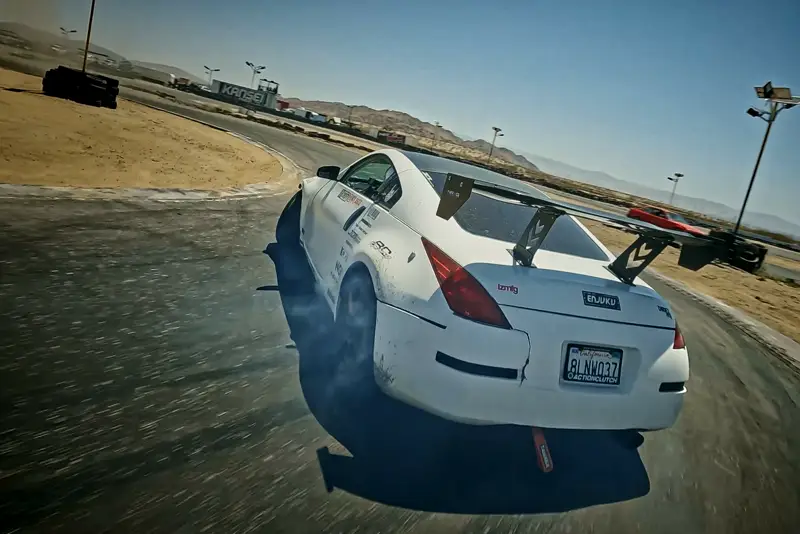FPV drone chasing a drift car on a race track